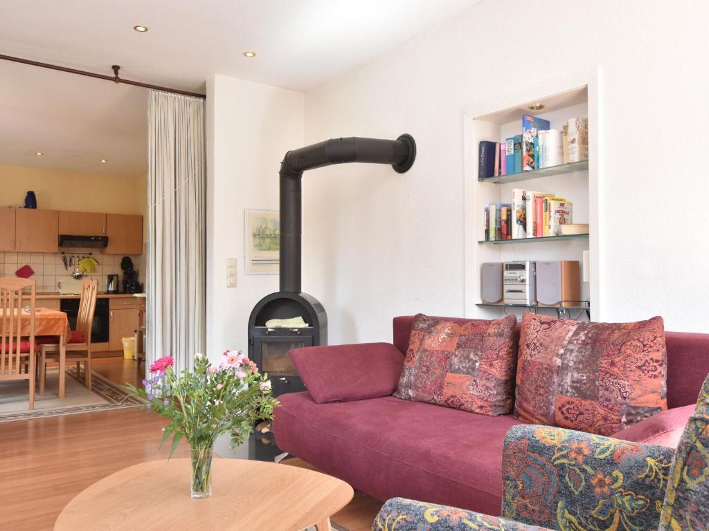 奥斯特巴德里克Quaint Apartment in Rerik near Sea的客厅配有紫色沙发和燃木炉。