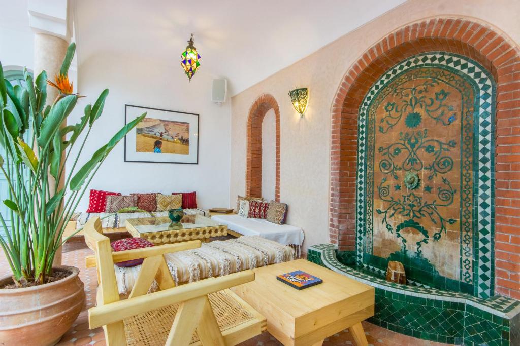马拉喀什里亚德海伦庭院旅馆的客厅配有沙发和桌子
