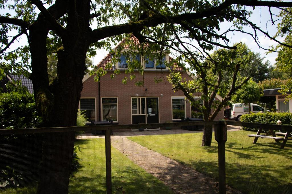 迪弗尔Appartementen Aangenaam - Olde Horst Diever的前面有棵树的建筑