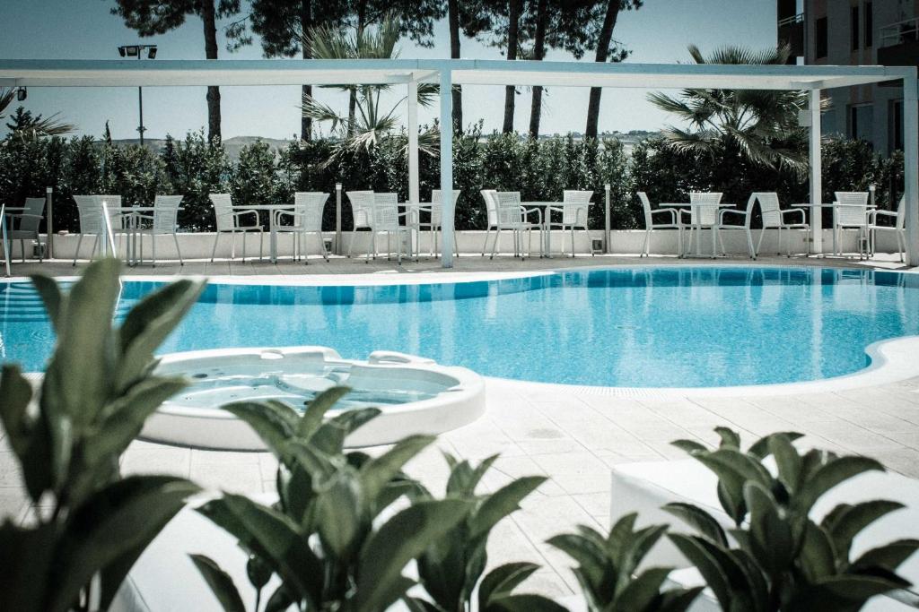 泰尔莫利欧罗巴酒店的一个带白色椅子和桌子的游泳池