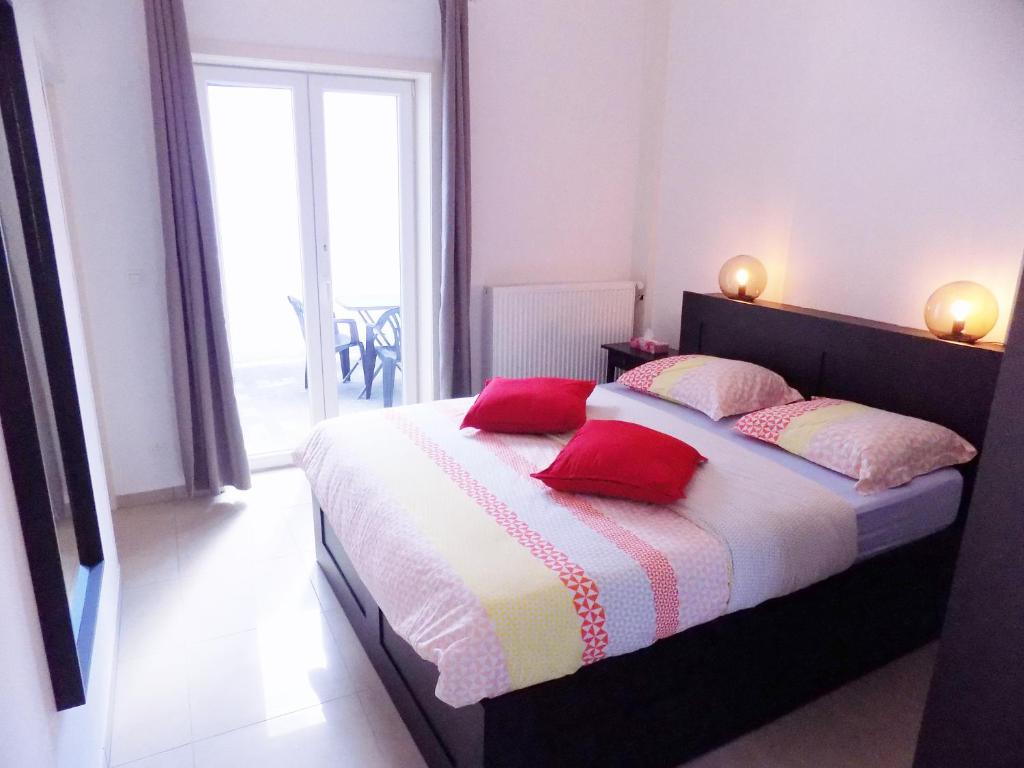 沙勒罗瓦La Lodelinsartoise - Meublé de vacances 3 clés的一间卧室配有一张带红色枕头的床