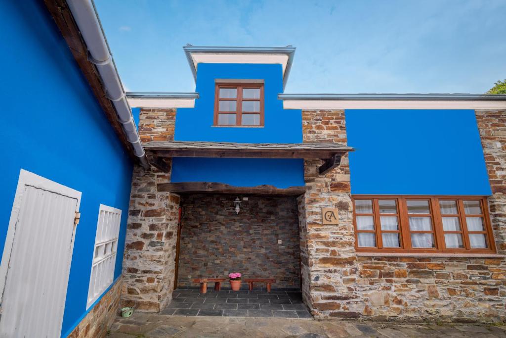 卡斯特罗波尔Casa de Aldea el Ferreirón的蓝色房子,在庭院里设有野餐桌