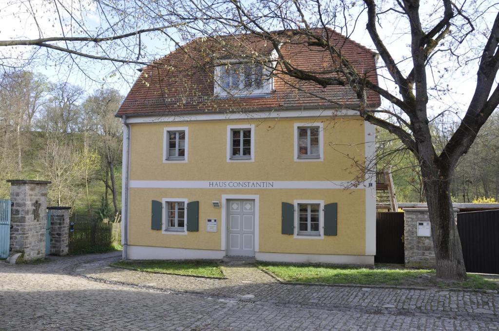魏玛Haus Constantin的前面有一棵树的黄色房子