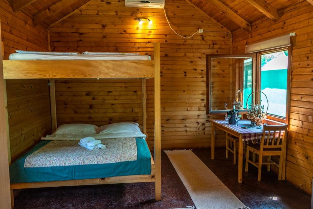 PonariWooden Village Resort的一间卧室配有一张双层床、一张桌子和一张书桌。