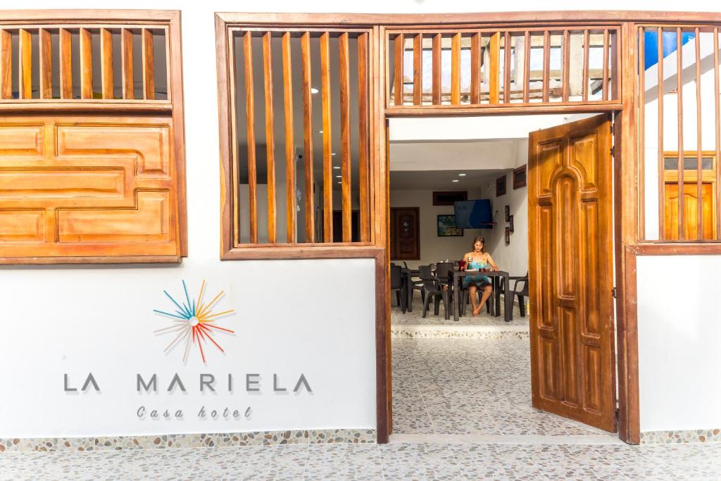 扎普祖罗Casa Hotel La Mariela的一间咖啡馆的大门,后面有一位女士