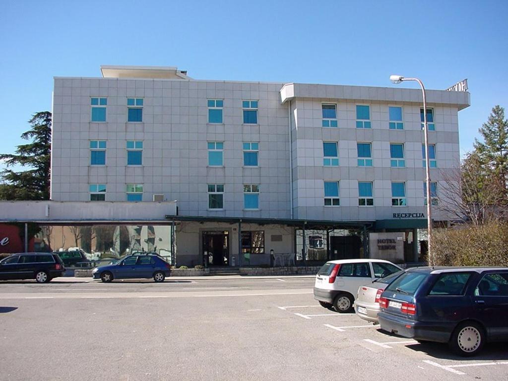 塞扎纳塔博尔酒店的停车场内停放汽车的大型建筑
