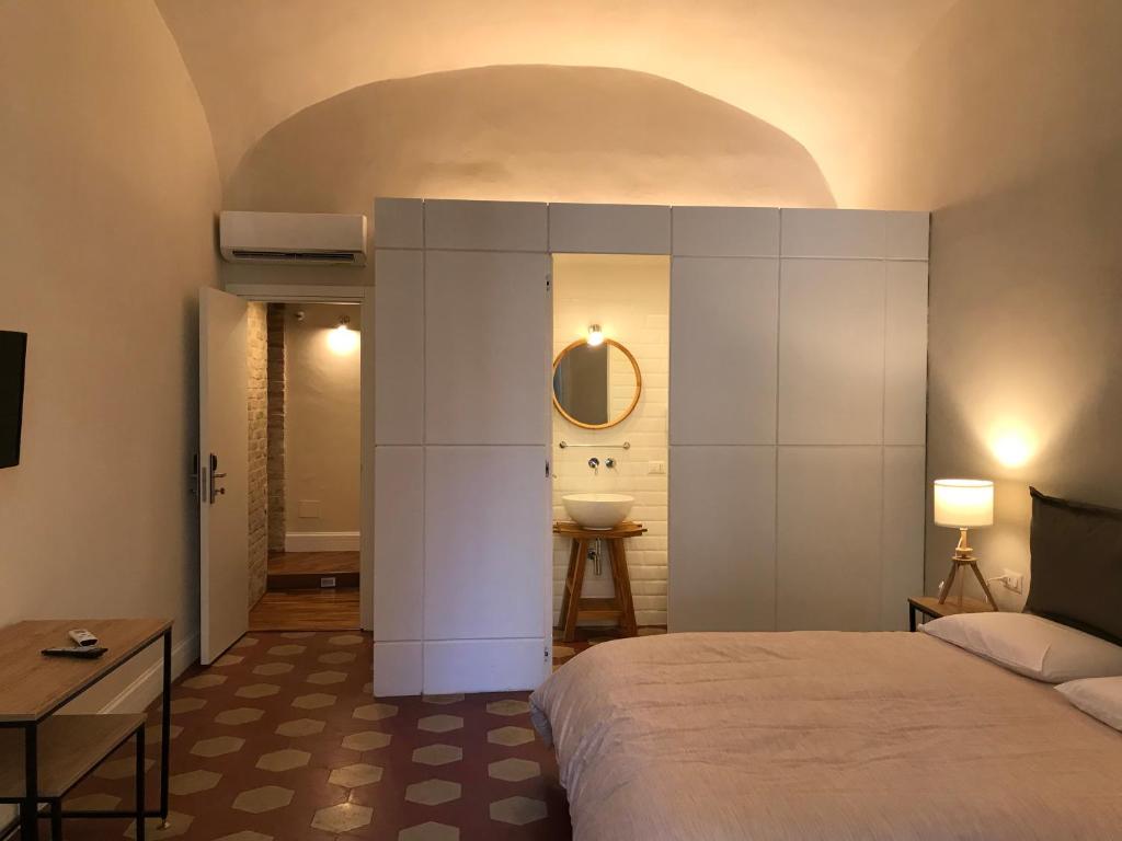 那不勒斯Palazzo Pignatelli的一间卧室配有一张床,浴室设有水槽