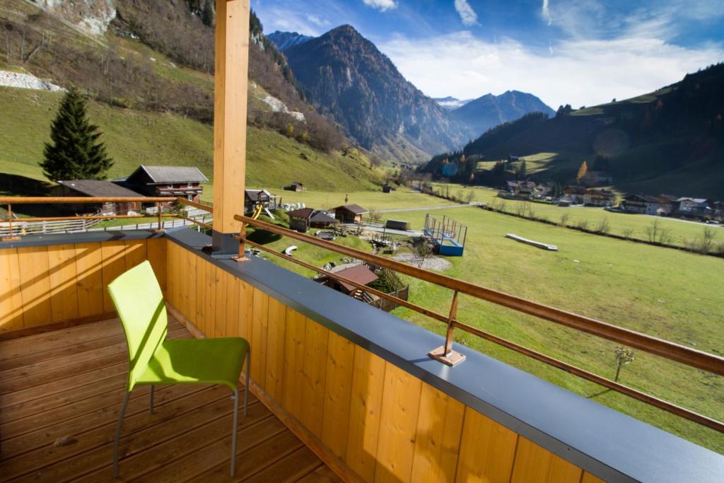 HüttschlagFamilienhotel Oberkarteis的山景阳台上的绿色椅子