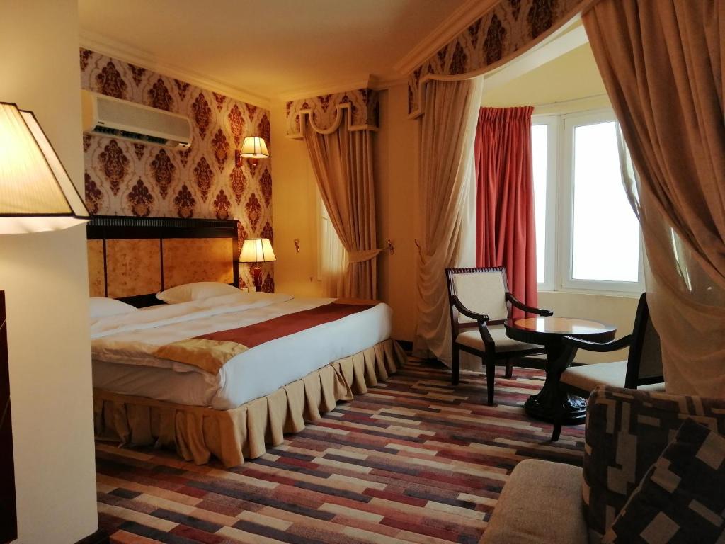 马斯喀特德马斯酒店的酒店客房配有一张床铺和一张桌子。
