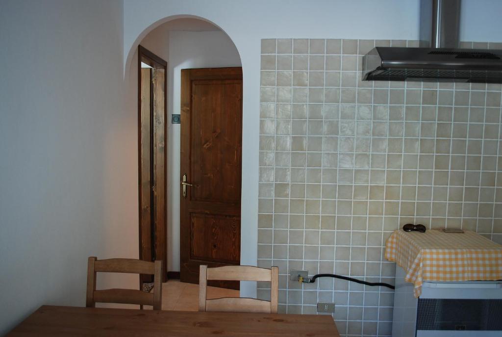 BarigazzoCasa rosa sull'appennino tosco emiliano的厨房配有两把椅子和一张桌子,并设有一个门
