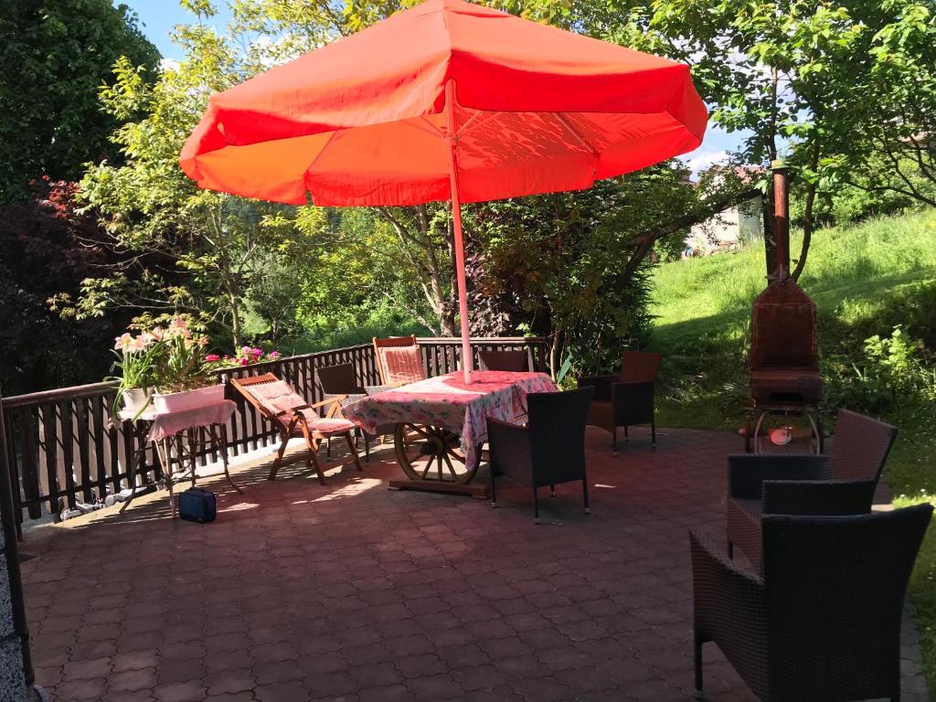 索利纳Apartament Roti Solina的露台上的一张桌子和一把红色遮阳伞