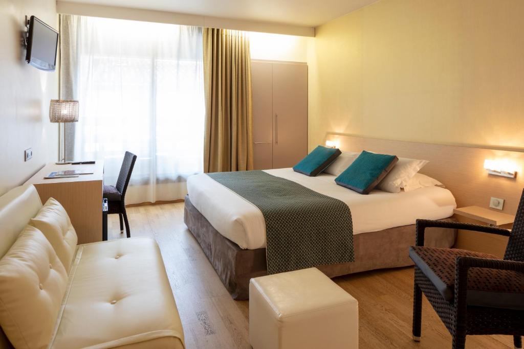 屈伊朗Hotel La Chaumière的酒店客房,配有床和沙发