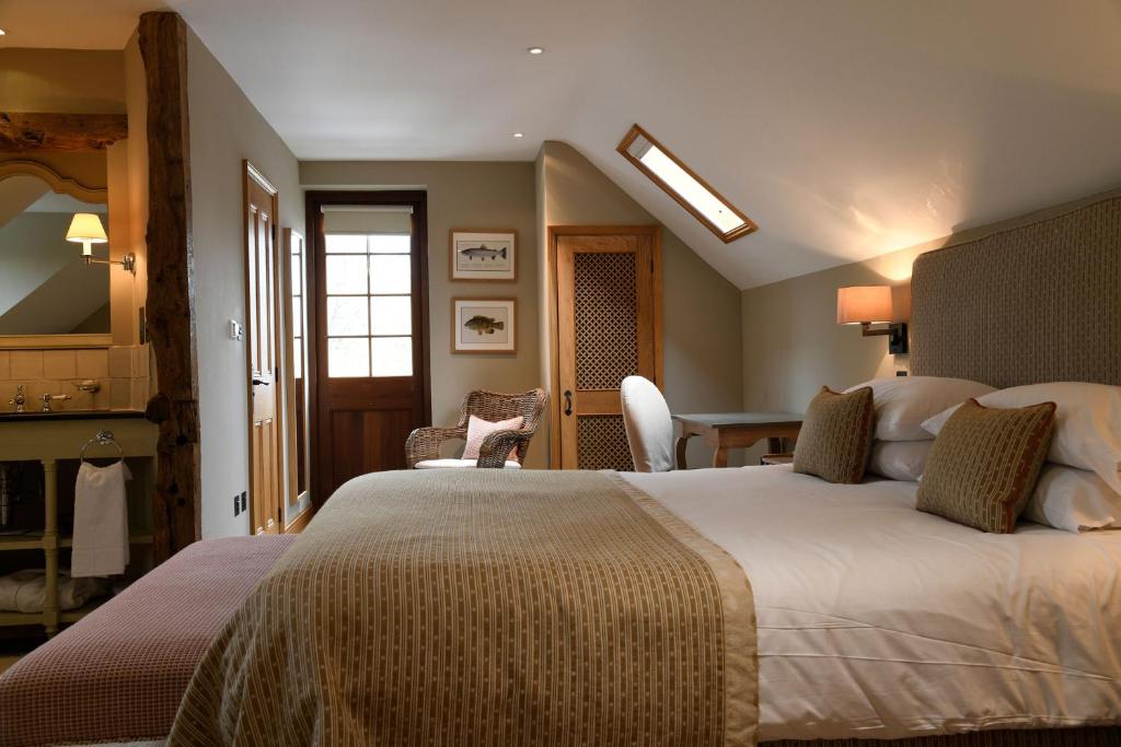 马尔堡The Bell at Ramsbury的酒店客房设有一张大床和一张书桌。