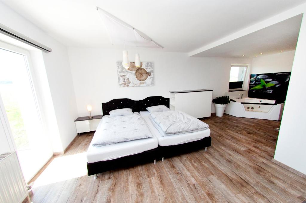 SierningGasthof Alpenblick的铺有木地板的客房内设有一间卧室和一张床。
