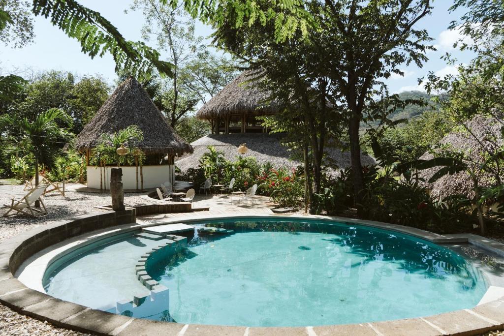 南圣胡安Dreamsea Surf Resort Nicaragua的一座带小屋的房屋前的游泳池