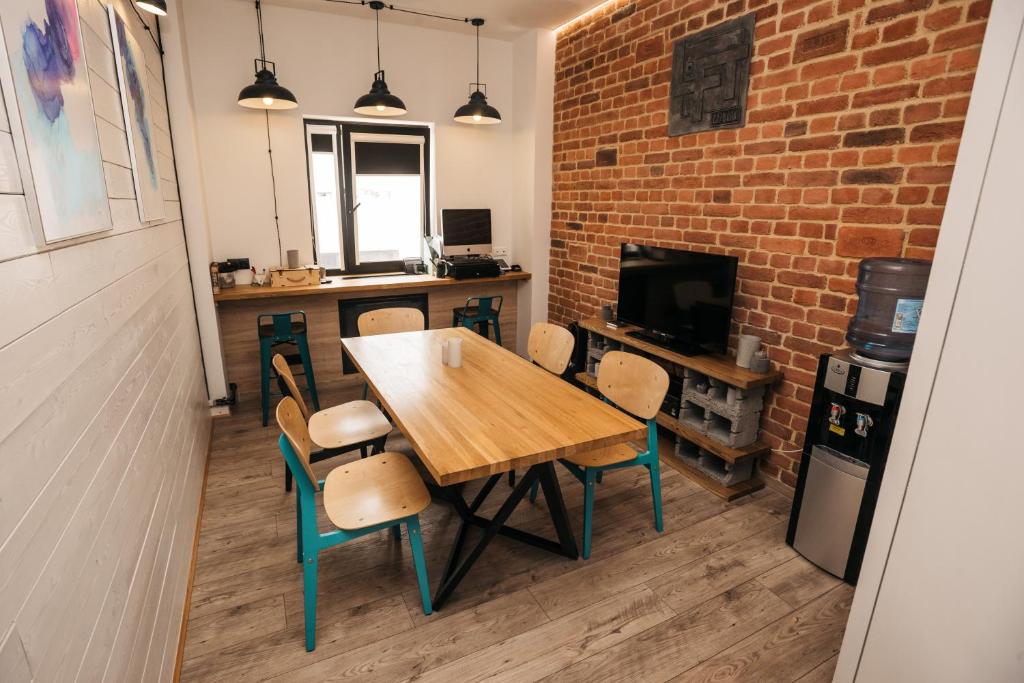 别尔哥罗德Хостел LOFT的一间设有桌椅和砖墙的用餐室