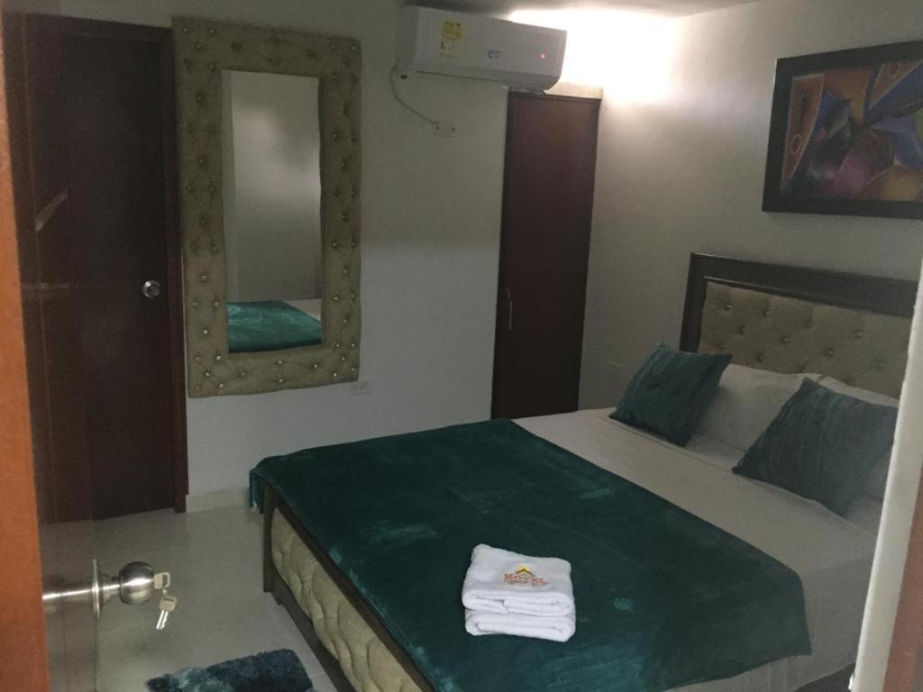 里奥阿查Hotel Atardecer Guajiro的一间卧室配有一张带绿毯和镜子的床