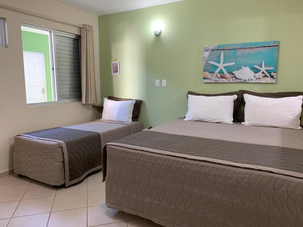 弗洛里亚诺波利斯东海客栈的一间卧室设有两张床和窗户。