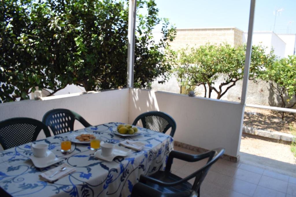 玛丽娜迪曼卡维萨Alba Chiara - Villa con Giardino的阳台上的一张桌子上摆放着蓝白桌布