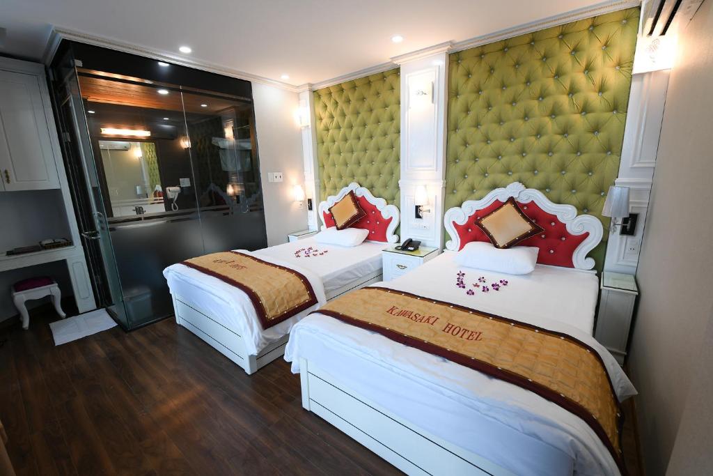 内排Kawasaki Noi Bai Hotel的两张位于酒店客房的床,配有两张sidx sidx单人床