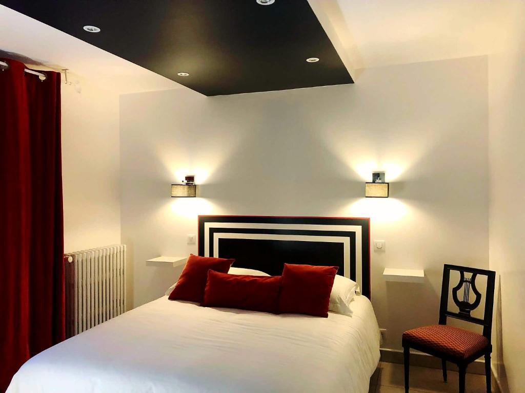 普罗万coté remparts的一间卧室配有一张带红色枕头的床和一把椅子