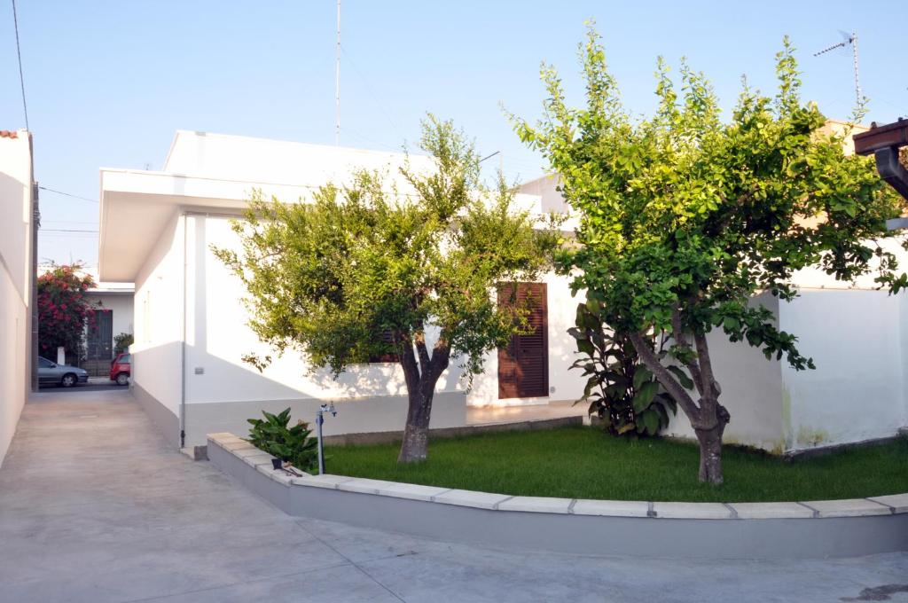 朱尔迪尼亚诺Casa Vacanze Eufemia的白色房子前面的两棵树