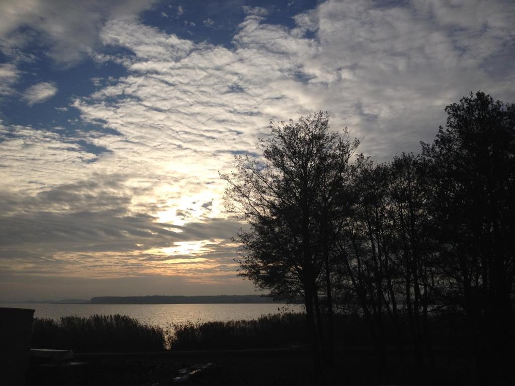 梅尔诺Pokoje Gościnne的湖前有树的云天