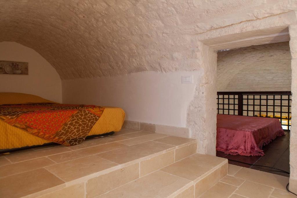 阿尔贝罗贝洛Da Santino的一间卧室设有两张床和砖墙