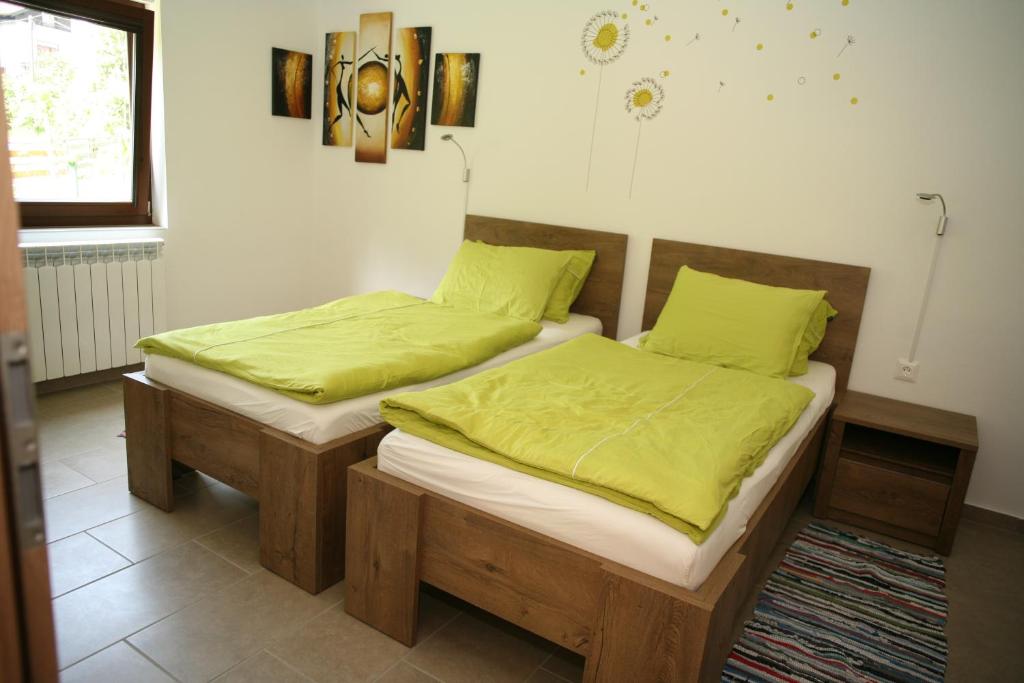 采尔克诺Apartma Opalika的卧室设有两张单人床,配有绿色床单