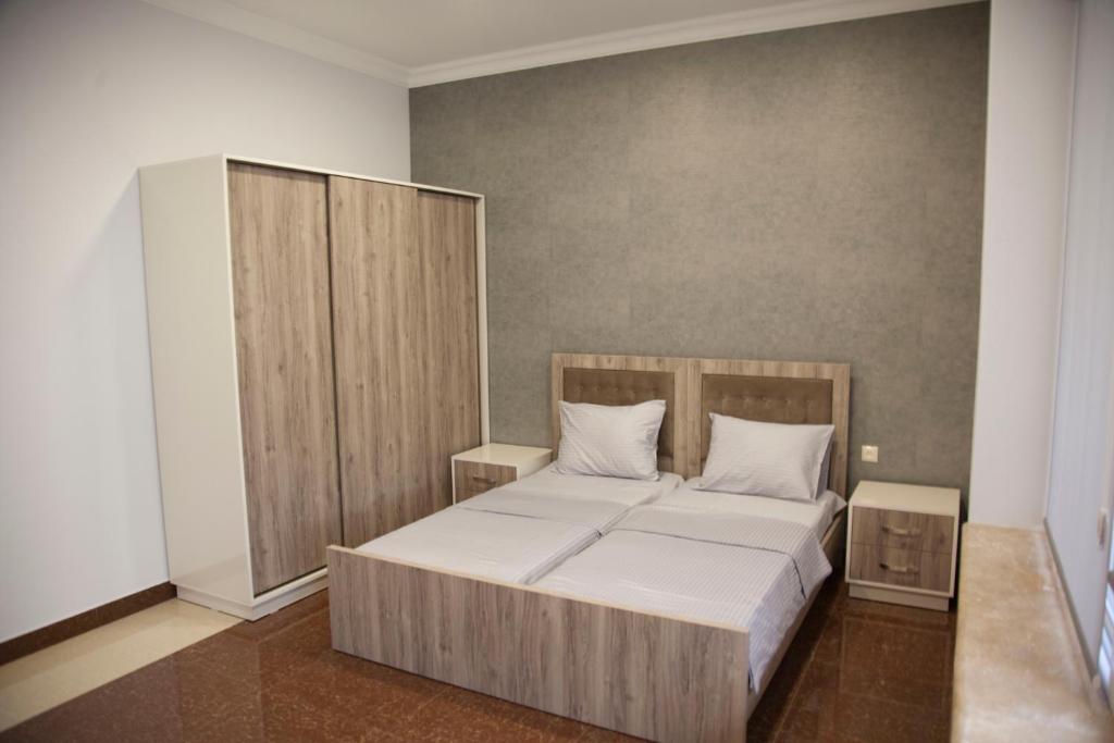 埃里温Liko Hostel的一间卧室配有一张带木制床头板的床