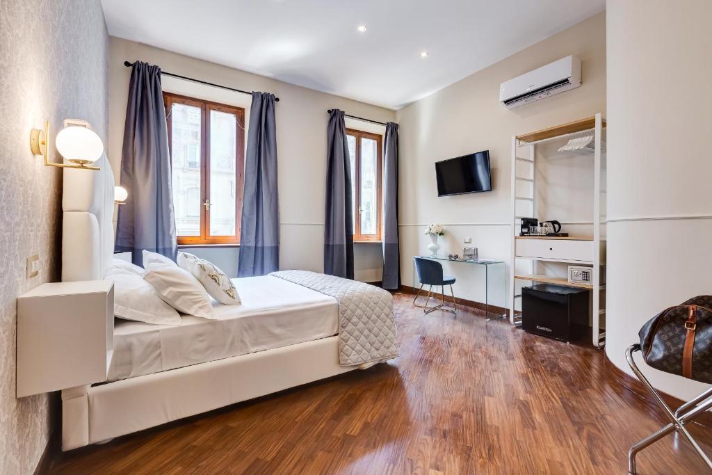 罗马Trevi Private Suites by Premium Suites Collection的卧室配有一张白色大床和一张书桌