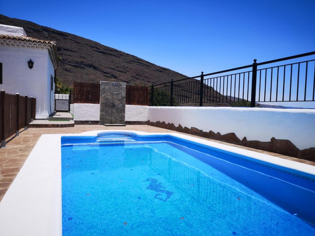 坎德拉里亚Sunset Las Hadas的一座房子后院的蓝色游泳池