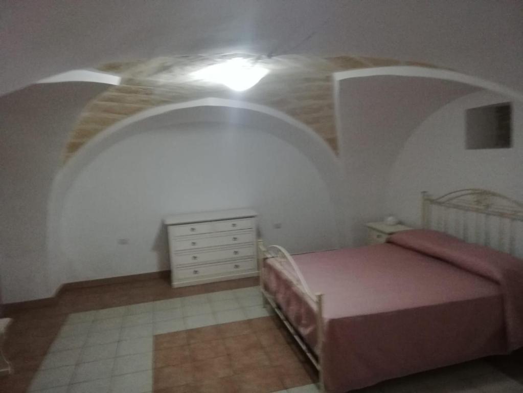 曼杜里亚Casa Daniela的卧室配有粉红色的床和梳妆台。