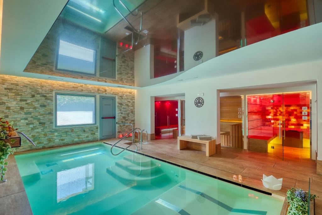 乌尔巴尼亚Boutique Hotel Bramante & SPA的一座大型游泳池,位于带房子的房间里