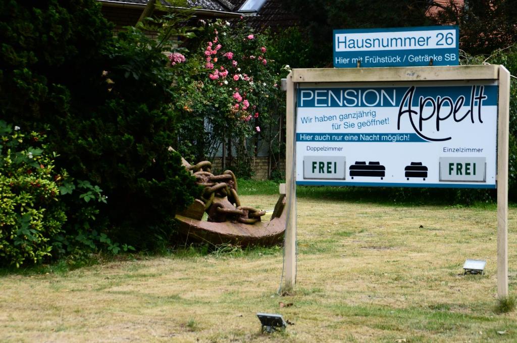 库克斯港Pension Appelt的坐在花园旁的草上的一个标志