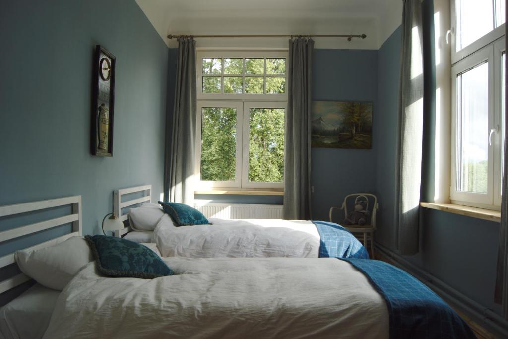 ZasaNyx & Iris的配有蓝色墙壁和窗户的三张床