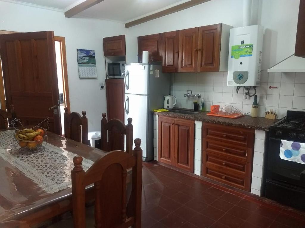 萨尔塔Ksa en la Linda的厨房配有桌子和白色冰箱。