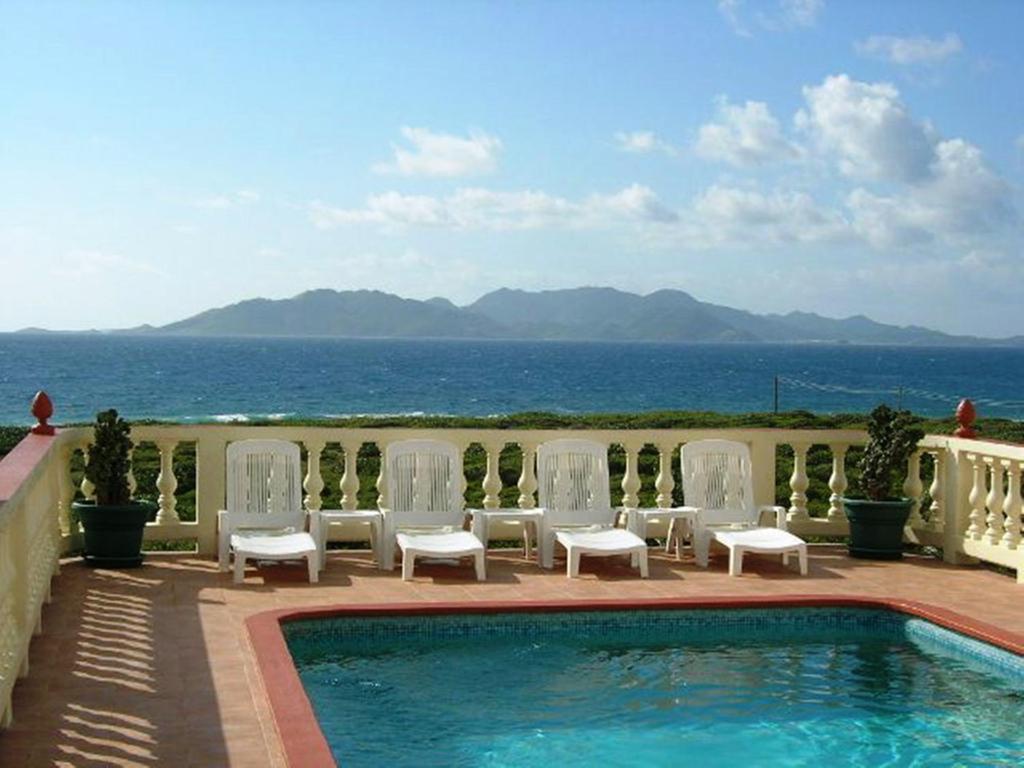 瓦利海洋露台公寓式酒店的一个带椅子的游泳池,享有海景