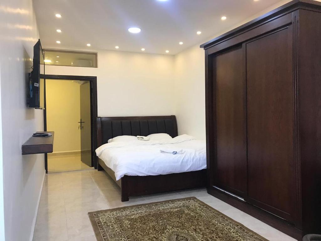 瓦迪穆萨Sultan Home的一间卧室配有一张床和一个大型木制衣柜