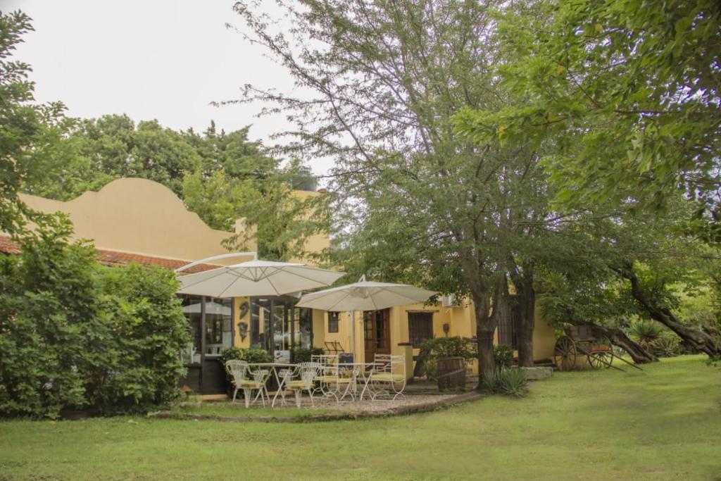 拉格兰哈El Cimarron Casa de Campo的院子里带桌子和遮阳伞的房子