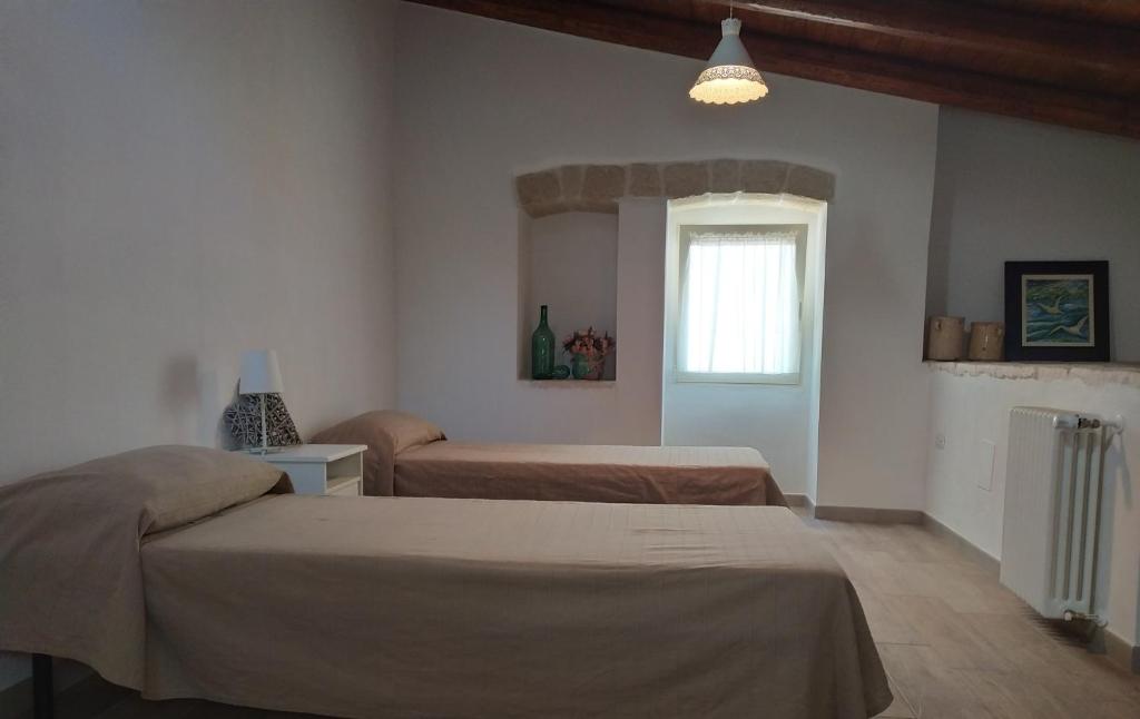 孔韦尔萨诺LA CASETTA 6058的一间卧室设有两张床和窗户。