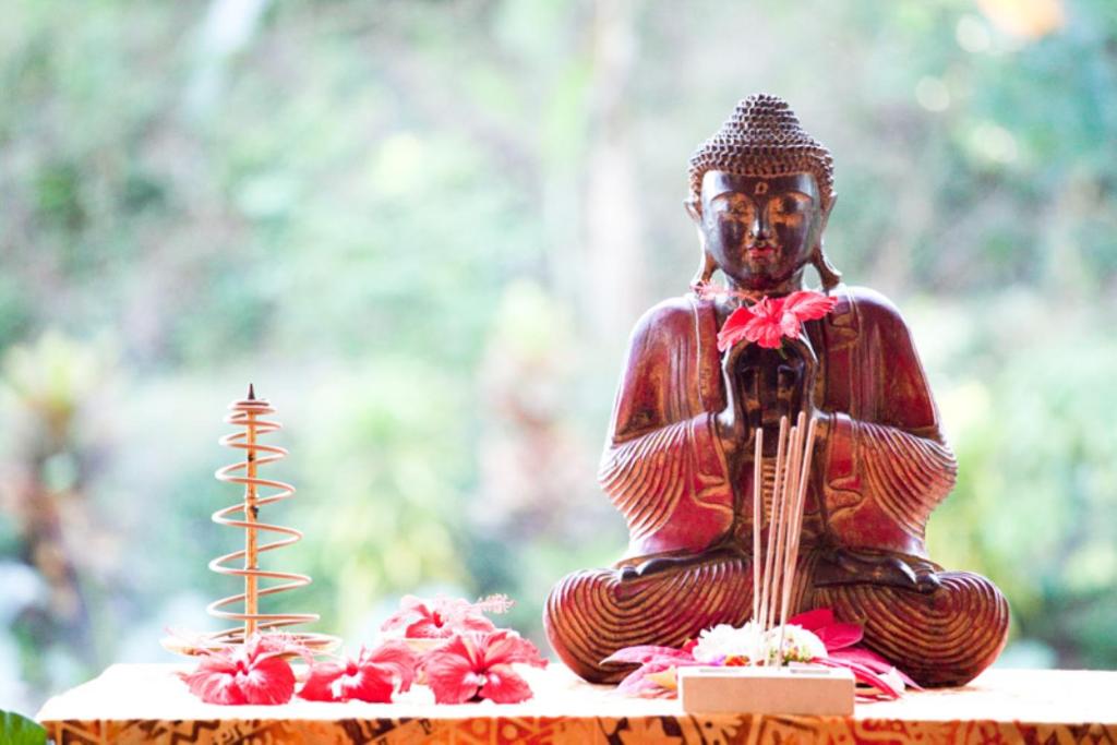 特贾库拉Gaia-Oasis Mountain Abasan的佛陀雕像,坐在桌子上,花朵