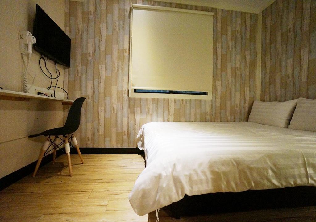 高雄远悦饭店 高雄爱河馆的卧室配有床、椅子和窗户。