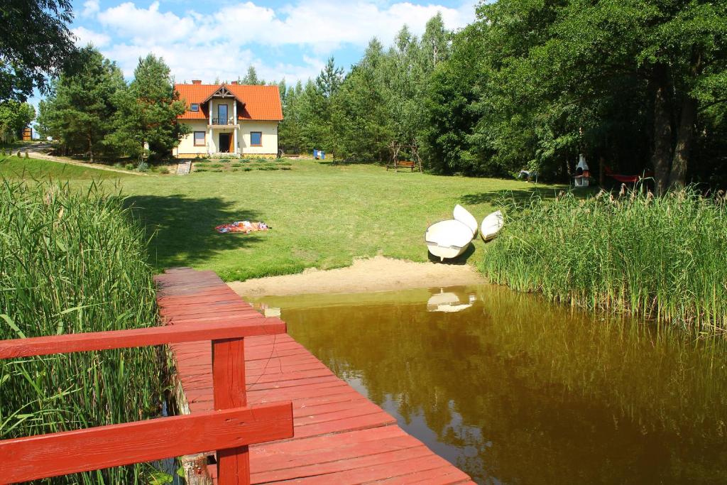 米科瓦伊基Bajkowe Mazury的一座木桥,在水体上,有房子