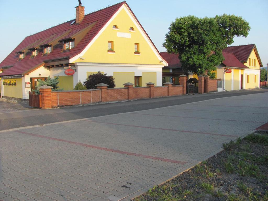 KrmelínŠindlerův Dvůr的街上有红色屋顶的黄色房子