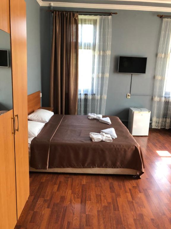 基兹洛沃茨克塞美尼奥迪旅馆的一间卧室配有一张床,上面有两条毛巾