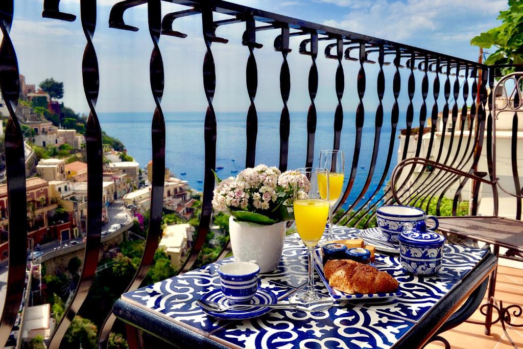 波西塔诺Gema Suites的阳台的蓝白桌子,上面摆放着食物和饮料