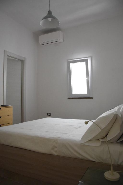 兰佩杜萨L'Argonauta的白色客房的一张床位,设有窗户