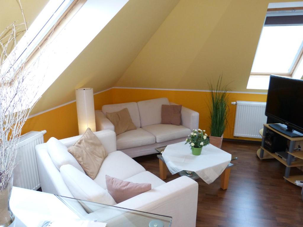 克吕茨Ferienwohnung Sommerwind的客厅配有2张白色沙发和电视