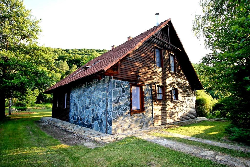 约什沃弗Marcell vendégház的一间棕色屋顶的小石头房子